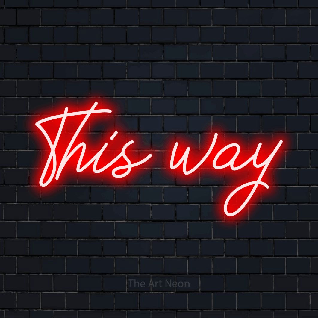 "This Way" script-style LED neon sign on a black brick wall