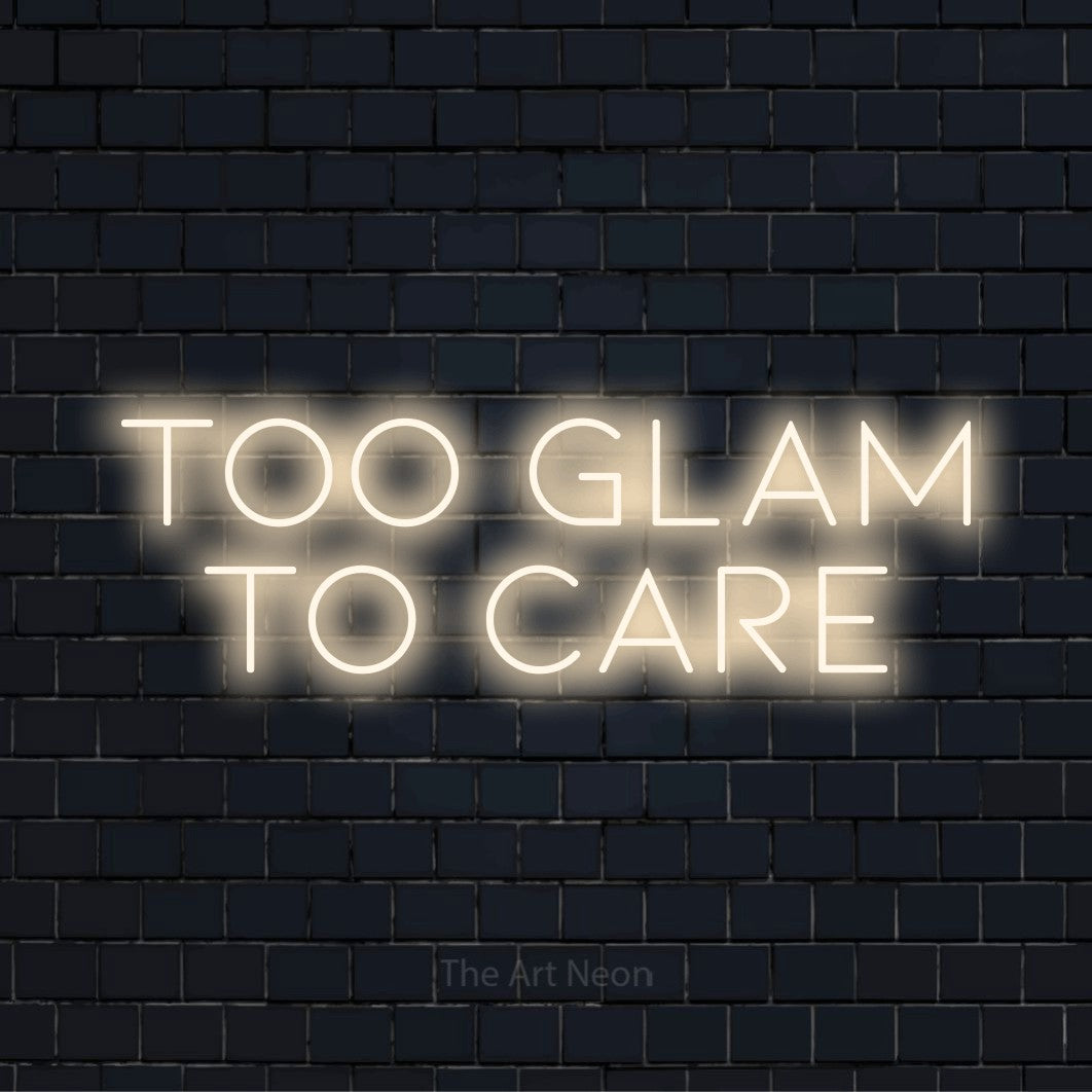 "Too Glam To Care" script-style LED neon sign on a black brick wall