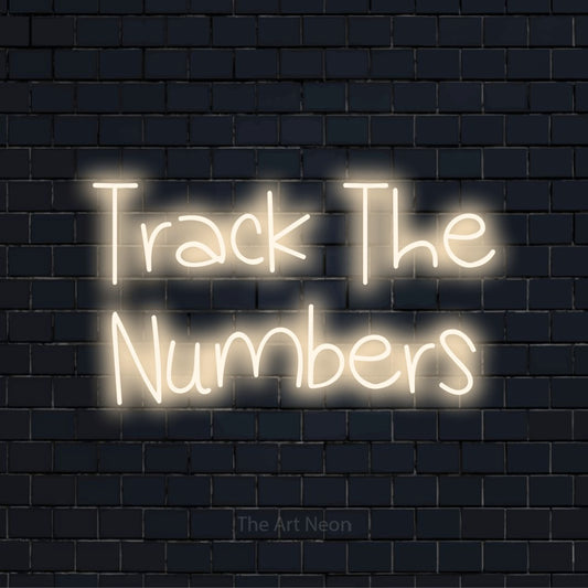 "Track The Numbers" LED neon sign on a black brick wall