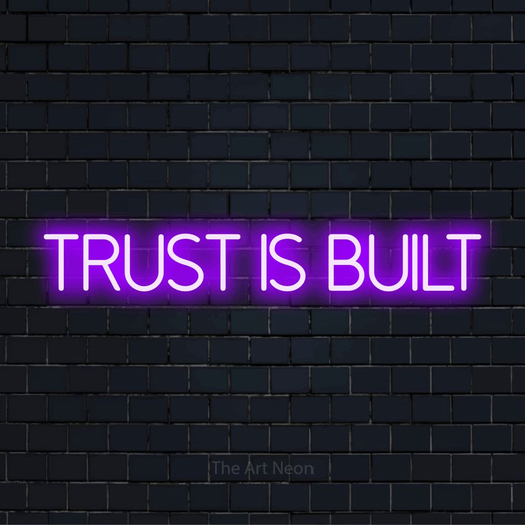 "Trust Is Built" text design with neon effect on a black brick wall