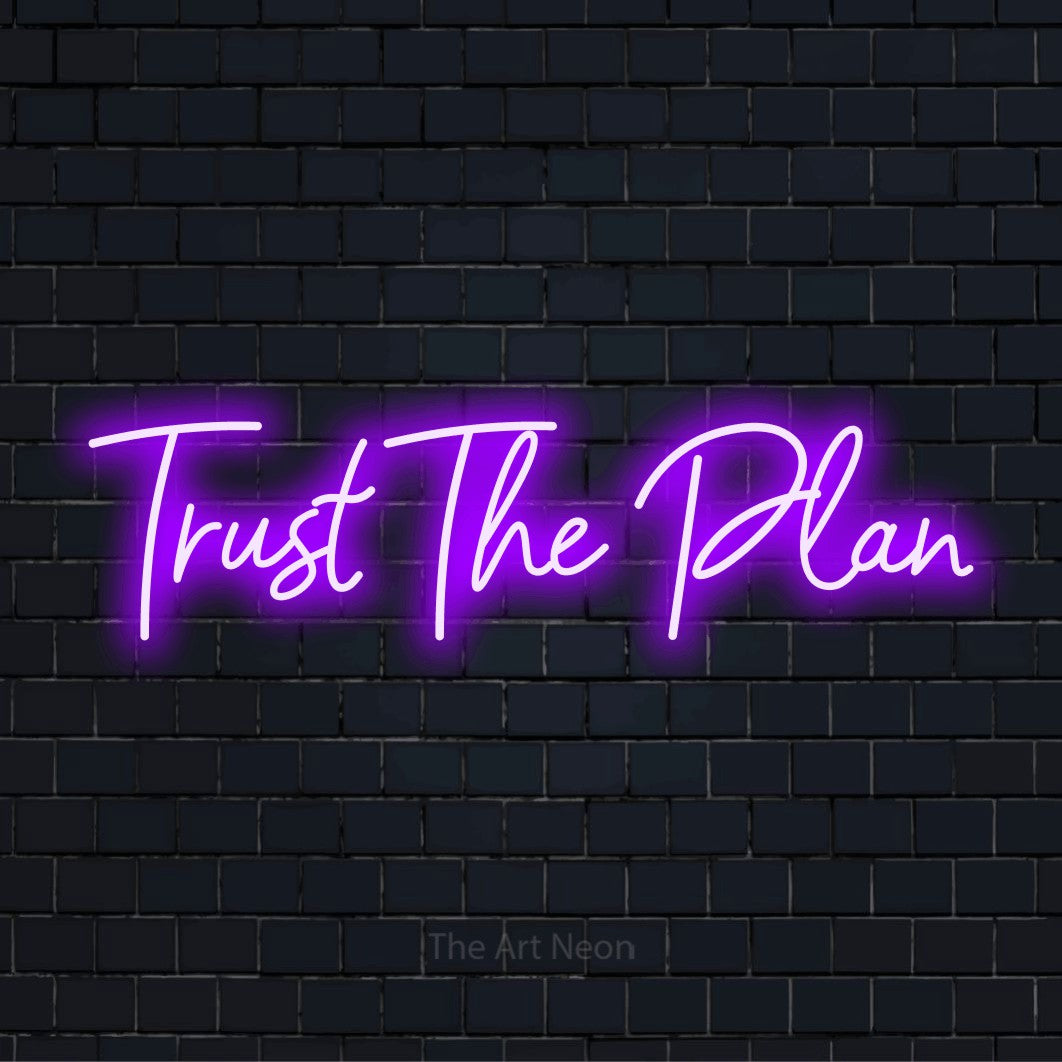 "Trust The Plan" glowing LED neon sign on a black brick wall