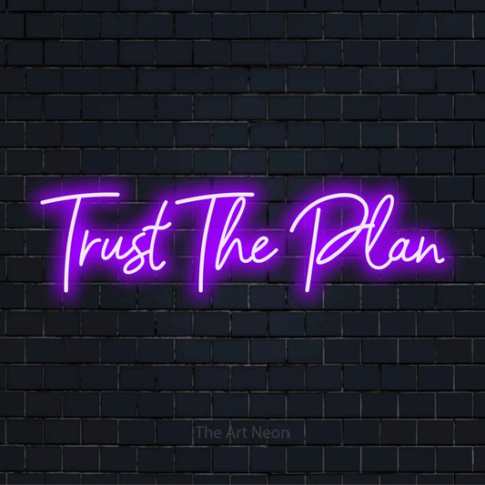 "Trust The Plan" glowing LED neon sign on a black brick wall