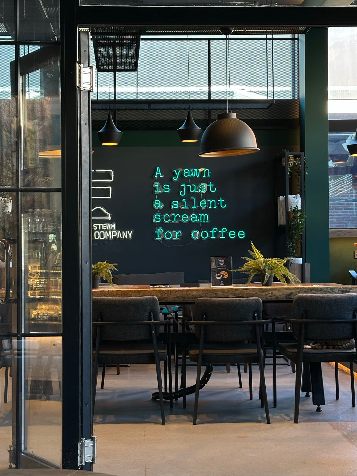 Turquoise quote LED neon sign installed inside a café