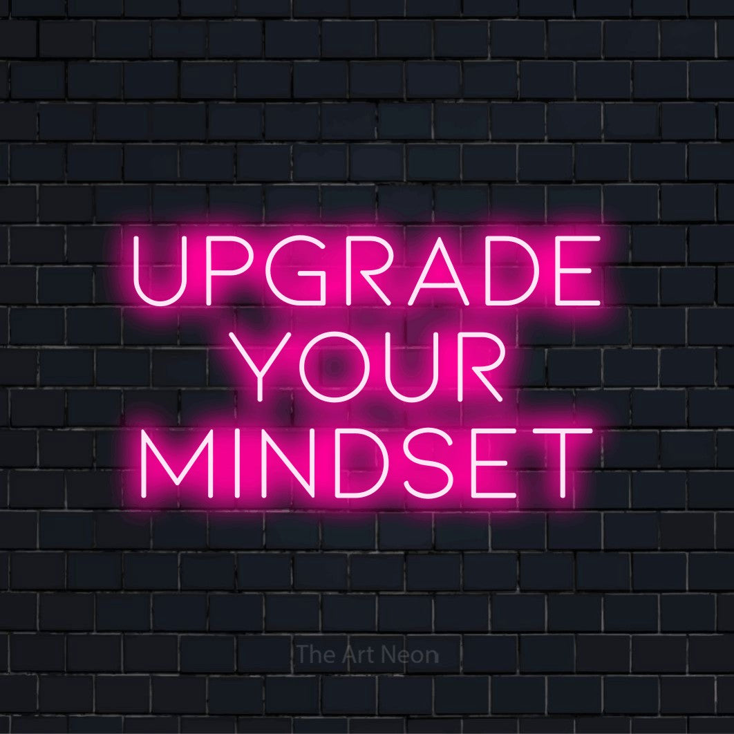 "Upgrade Your Mindset" text design with neon effect on a black brick wall
