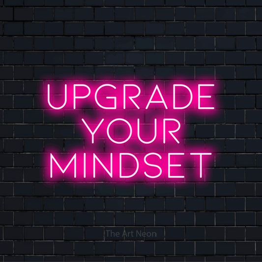 "Upgrade Your Mindset" text design with neon effect on a black brick wall