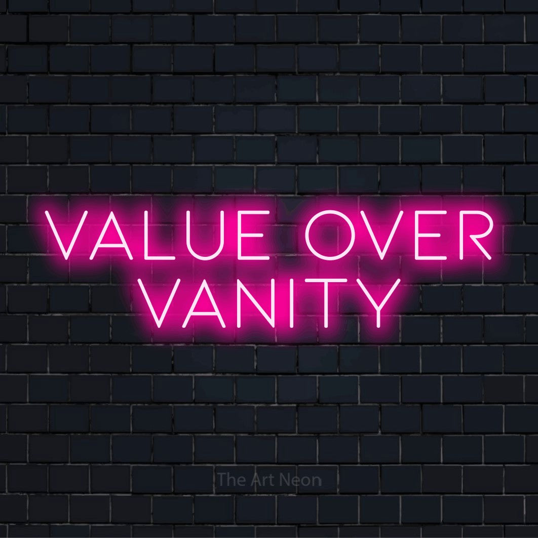 "Value Over Vanity" LED neon sign on a black brick wall