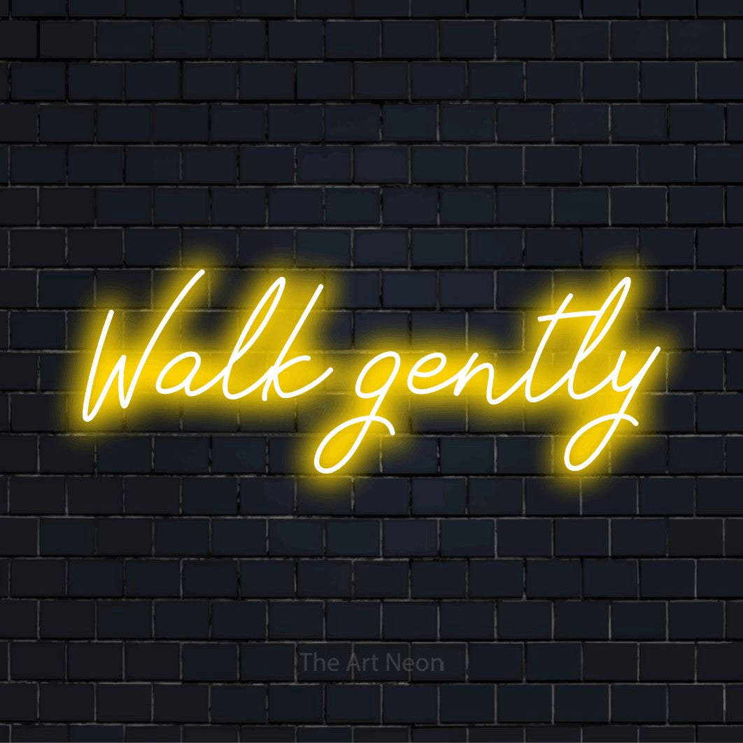 "Walk Gently" neon text design on a black brick wall