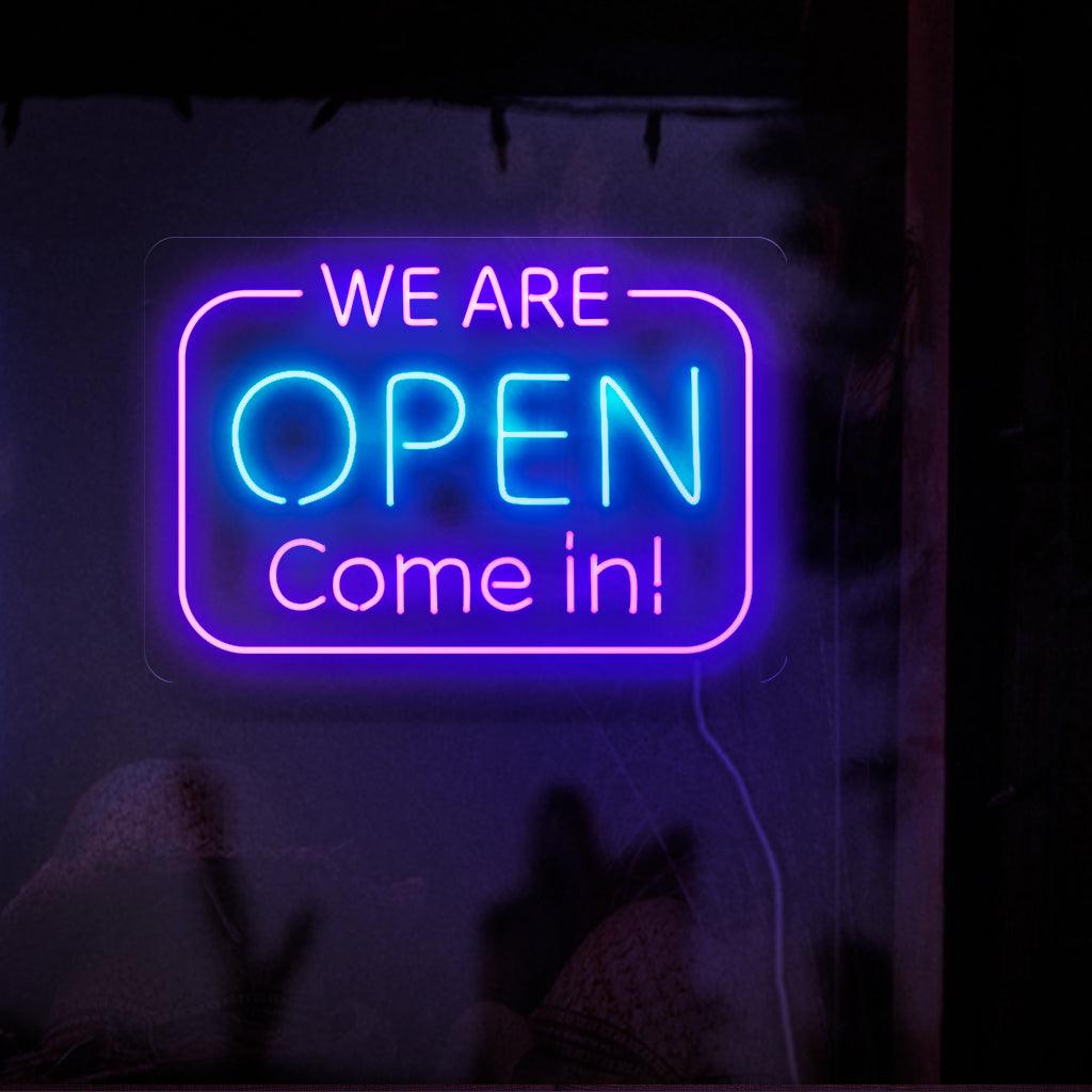 Um letreiro de neon cativante com letras grandes e brilhantes que dizem "Estamos abertos. Entre".