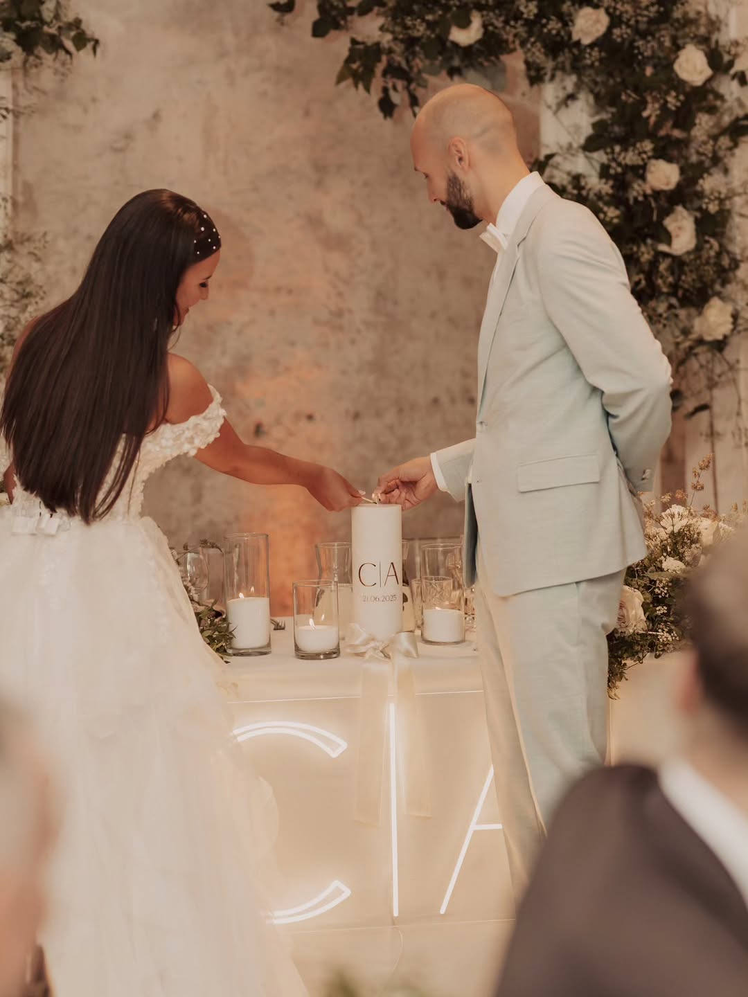 C and A initials LED neon sign above a candlelit wedding reception table