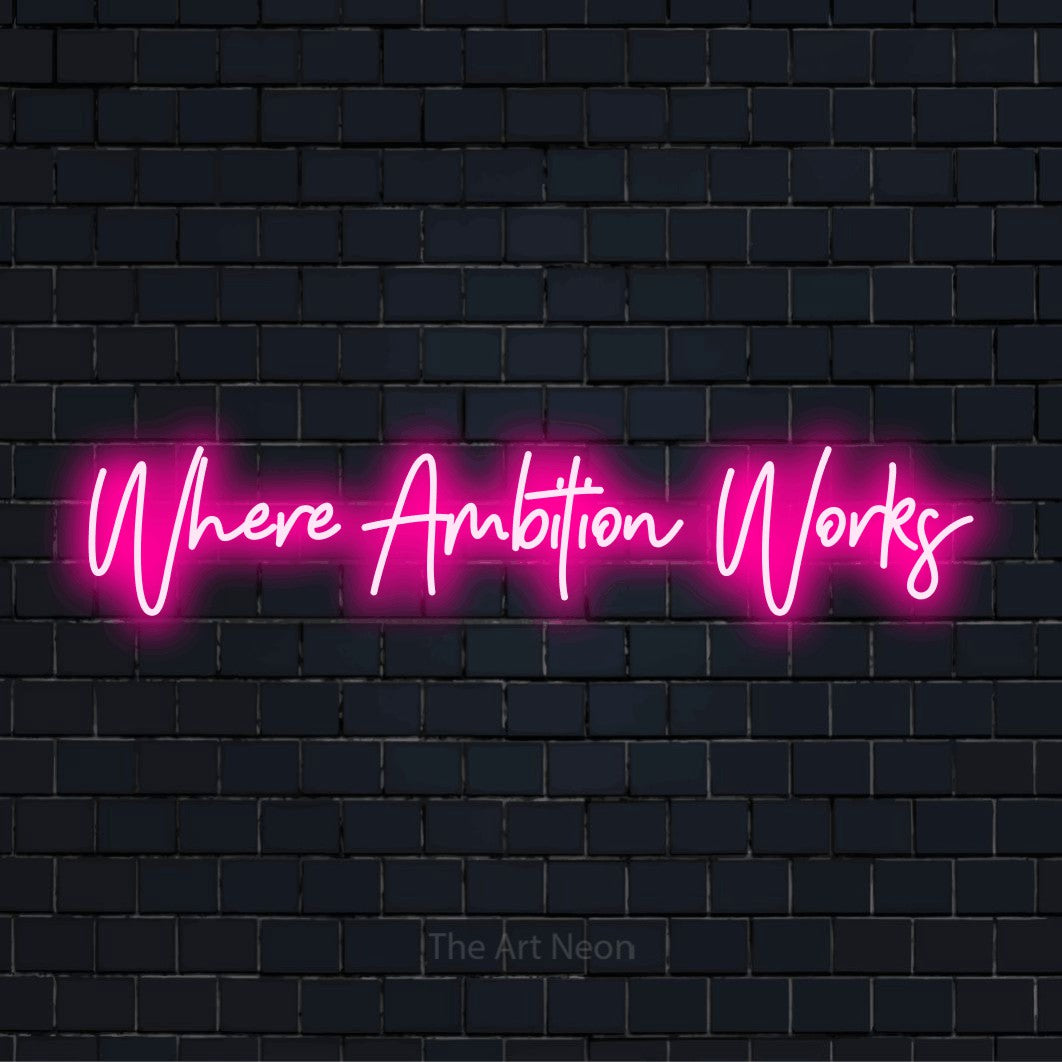 "Where Ambition Works" glowing LED neon sign on a black brick wall