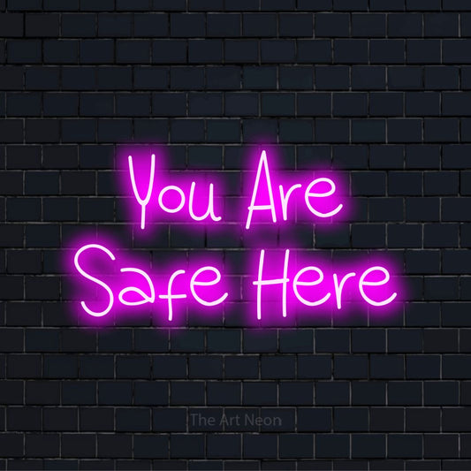 "You Are Safe Here" script-style LED neon sign on a black brick wall