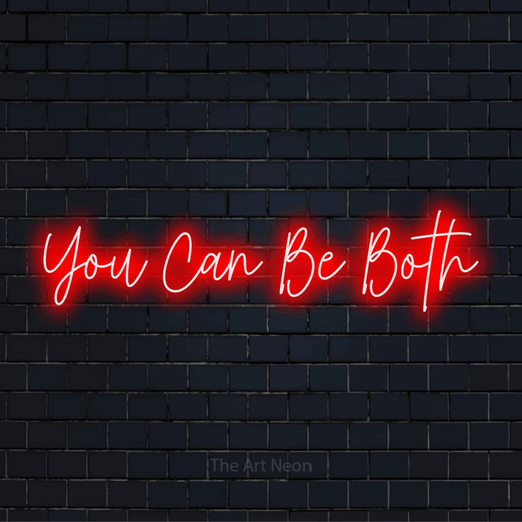 "You Can Be Both" neon text design on a black brick wall