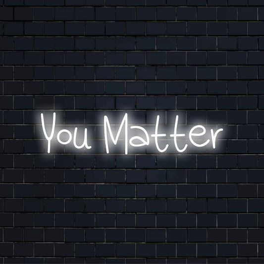 You Matter Neon Sign, glowing lettering on dark brick wall