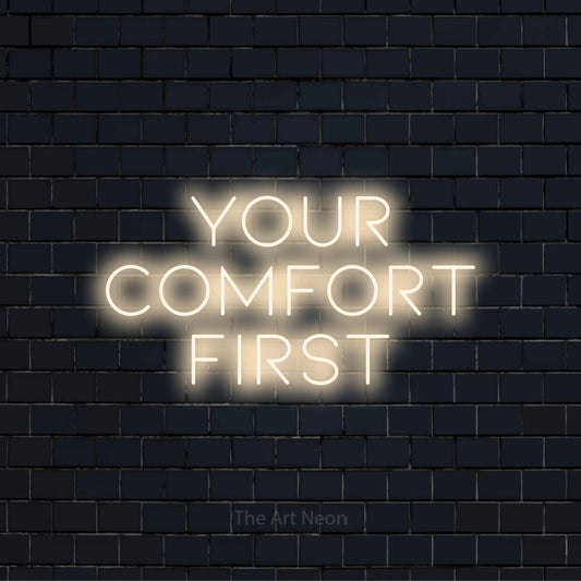 "Your Comfort First" LED neon sign on a black brick wall